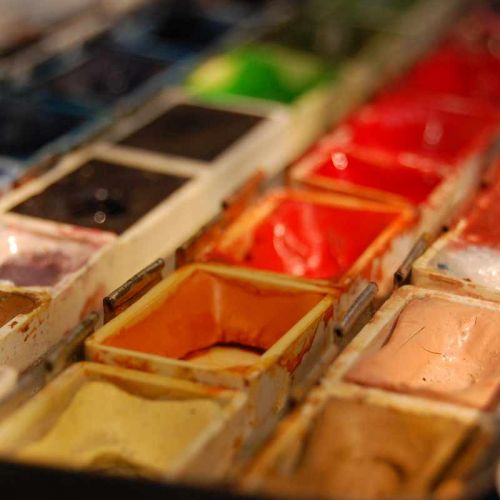 Großaufnahme von Aquarellkasten mit vielen kleinen Farbkästen in rot, gelb, braun, grün