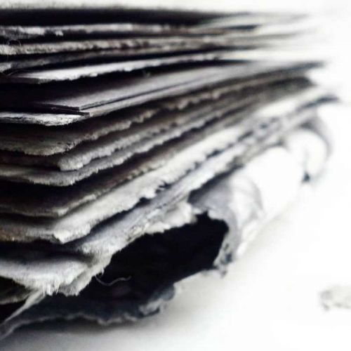 Stapel handgerissenes Aquarellpapier in Grautönen