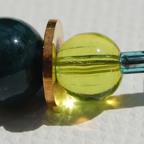 Limonengrüne Glasperle leuchtet im Sonnenlicht