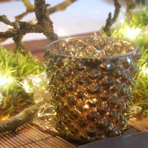 Versilbertes Glaswindlicht mit Ausbuchtungen im Glas. Hintergrund Äste und Moos.