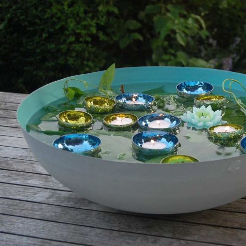 Große türkisfarbene Schale mit Glas-Schwimmlichtern in türkis und grün.